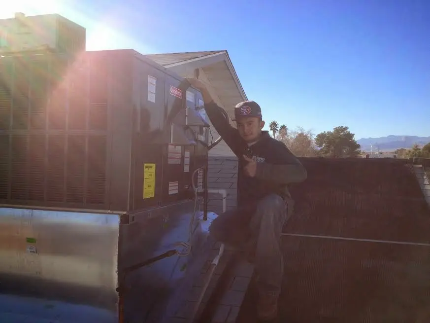 HVAC technician performing AC Tune-Up on a rooftop unit in Marana